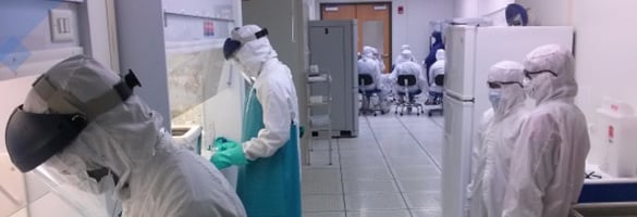 Students in medical suits working in a lab