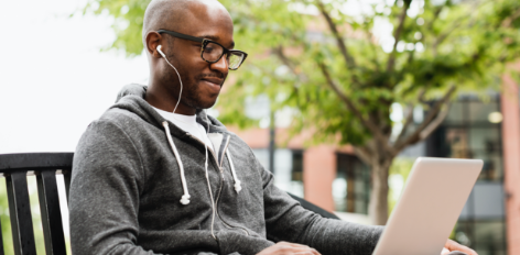 Student with headphones studies on laptop