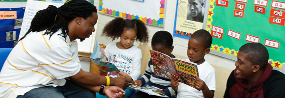 Teacher reading books with children students